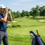 Frustrated golfer looking through a blurry rangefinder lens on a golf course.