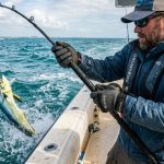 Angler wearing durable, top-rated fishing gloves while holding a rod.