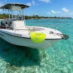 Boat anchored in turquoise Florida water with coiled anchor rope on deck.