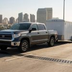 Vehicle towing trailer across bridge expansion joint