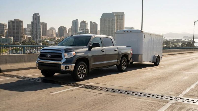 Vehicle towing trailer across bridge expansion joint