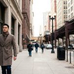 Stylish students wearing tailored winter coats while walking past Chicago historic buildings